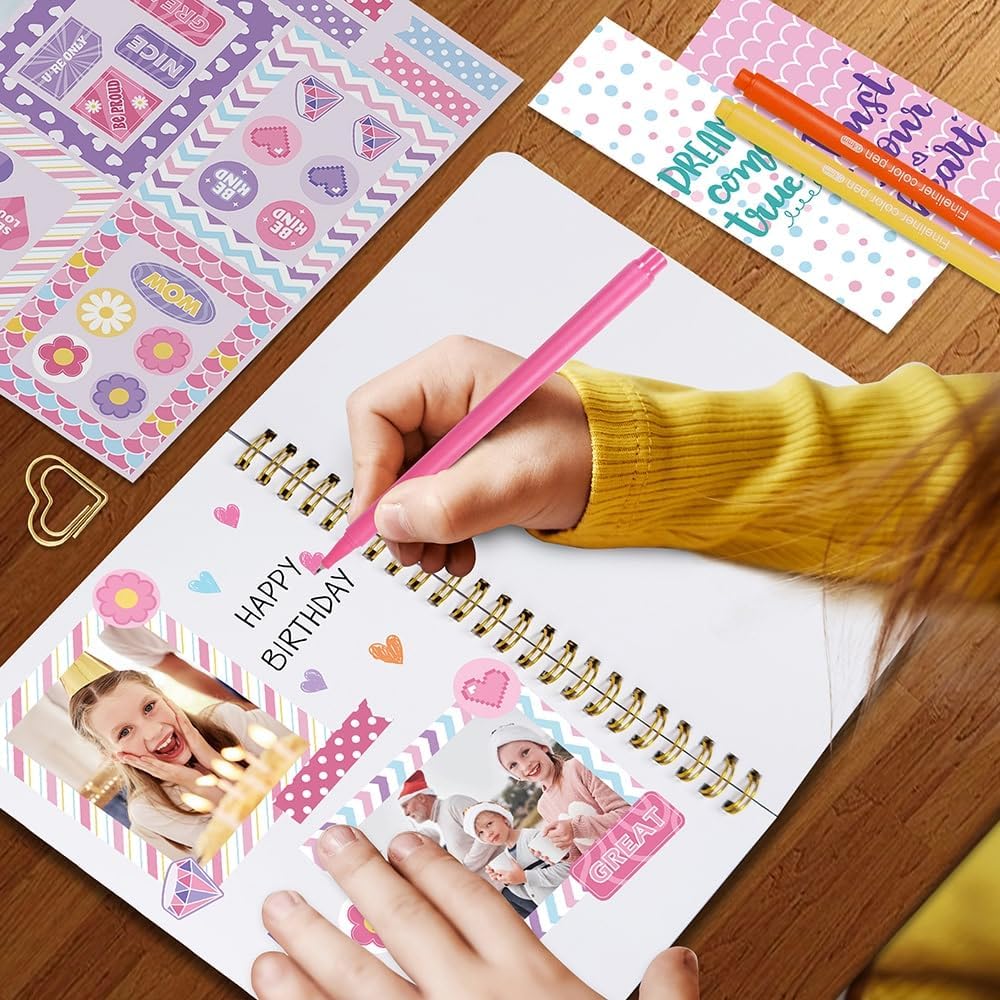 Person decorating a birthday card with colorful supplies on a wooden table.